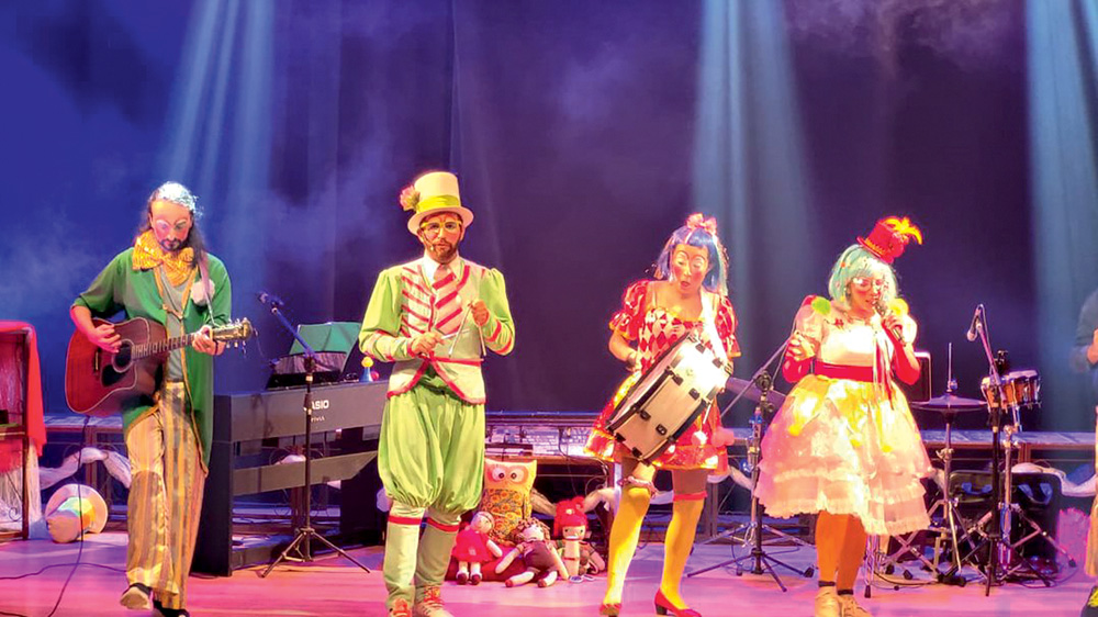 Crédito Acervo Pessoal – Conta Conta (2).JPG Quatro atores vestem roupas coloridas e tocam instrumentos em um espetáculo infantil