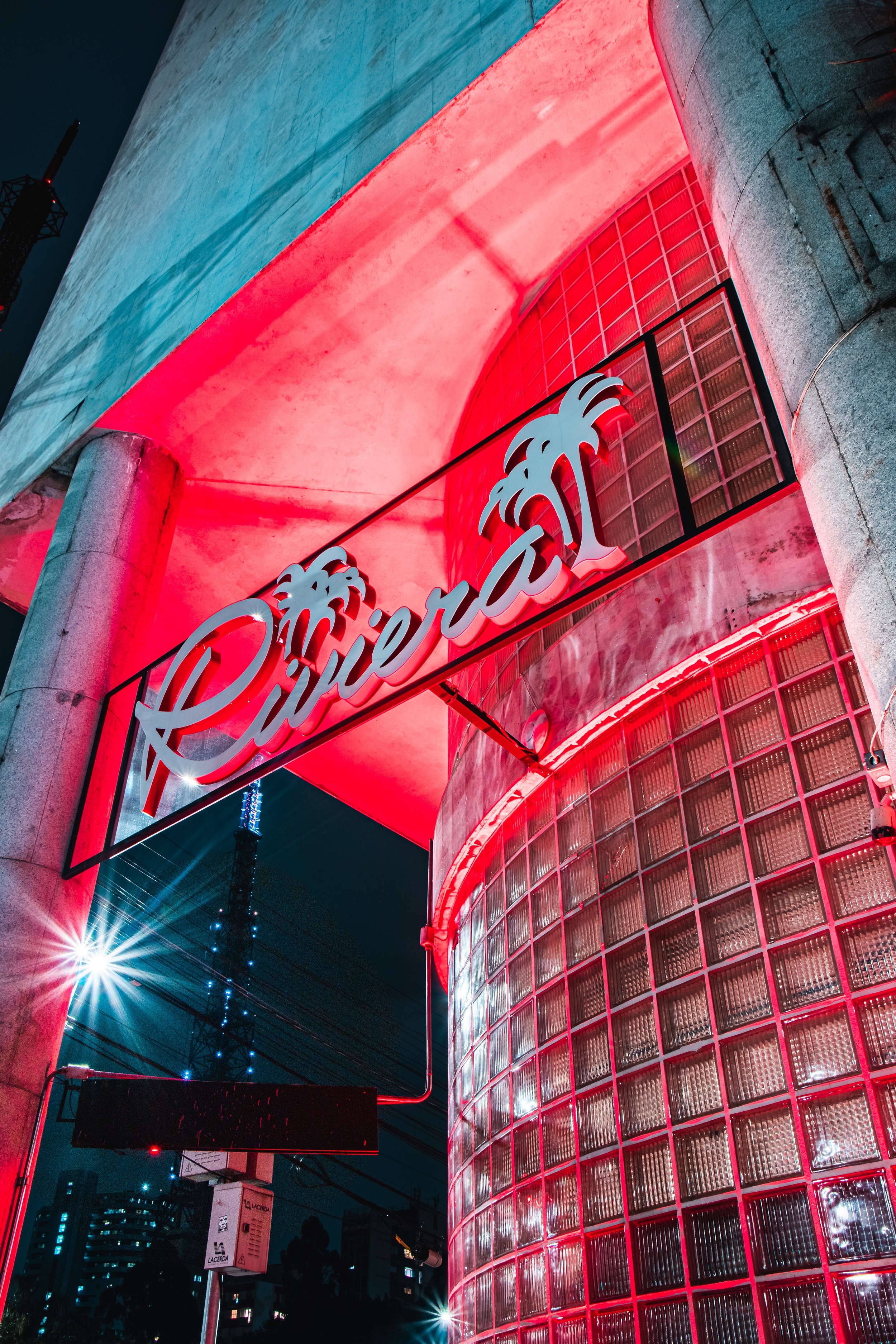 Fachada do Riviera Bar iluminado por luzes de LED de cor vermelha