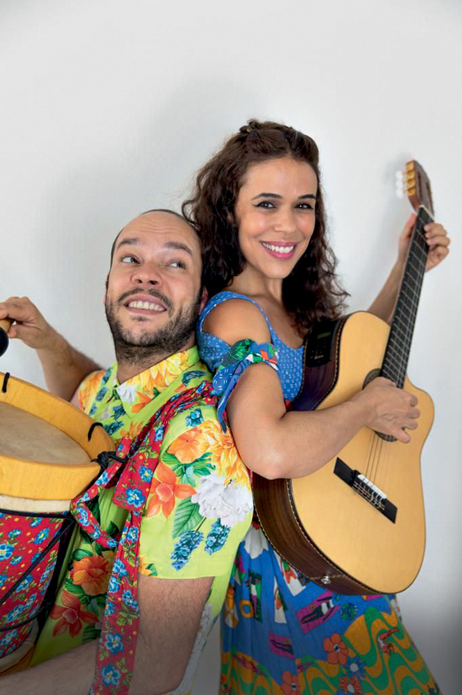 PODE SER ESTA divulgação (1).jpg Uma mulher e um homem seguram instrumentos e usam roupas coloridas