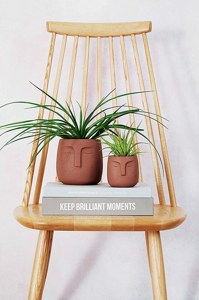 dois cachep&ocirc;s na cor marrom com estampa de rosto