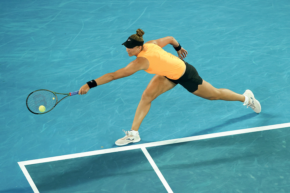 2022 Australian Open: Day 4 Bia joga em uma quadra de tênis, ela segura a raquete e veste uma roupa específica para o esporte. Seu cabelo loiro está preso em um coque