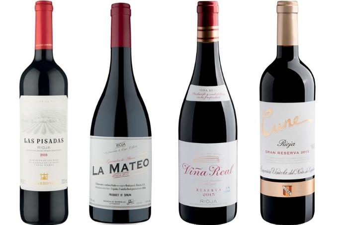 Quatro garrafas de vinho tinto sobre fundo branco