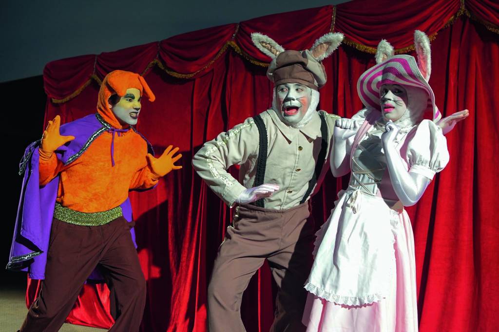 PODE SER ESTA crédito @grupovirafesta.JPG Um casal de atores fantasiados de coelho contracenam com um ator fantasiado de raposa. O casal demonstra estar assustado e a raposa faz um gesto de susto em direção a eles