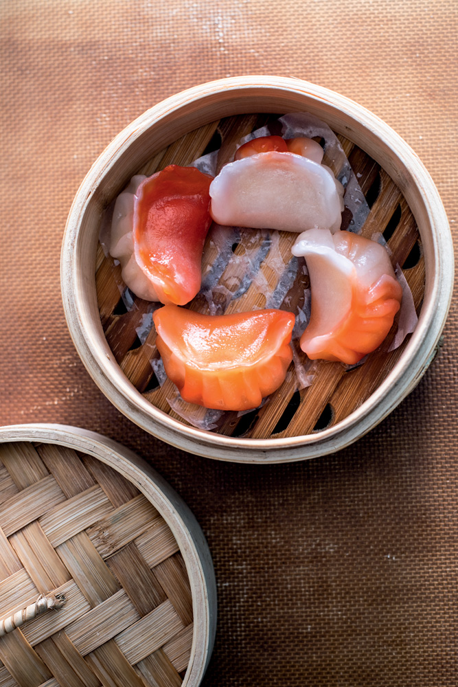 Yǒng Dim Sum Bar Pequenos dumplings de cor alaranjada servidos em recipiente de bambu