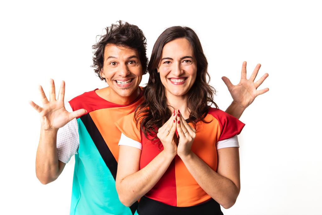 Wem e Diana Tatit em um fundo branco. Ambos são brancos e magros. Eles têm cabelos escuros e lisos, usam roupas com estampas geométricas e coloridas e posam em um fundo branco