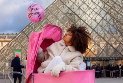 Ana Flávia posa em carrinho de bebê rosa em frente à pirâmide do Louvre.