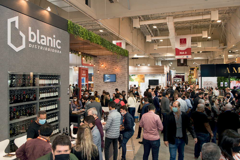 Ambiente de evento, cheio de pessoas e diferentes estandes