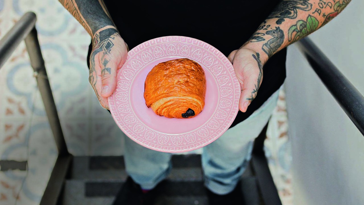 Pain au chocolat servido sobre pequeno prato raso de cor rosa
