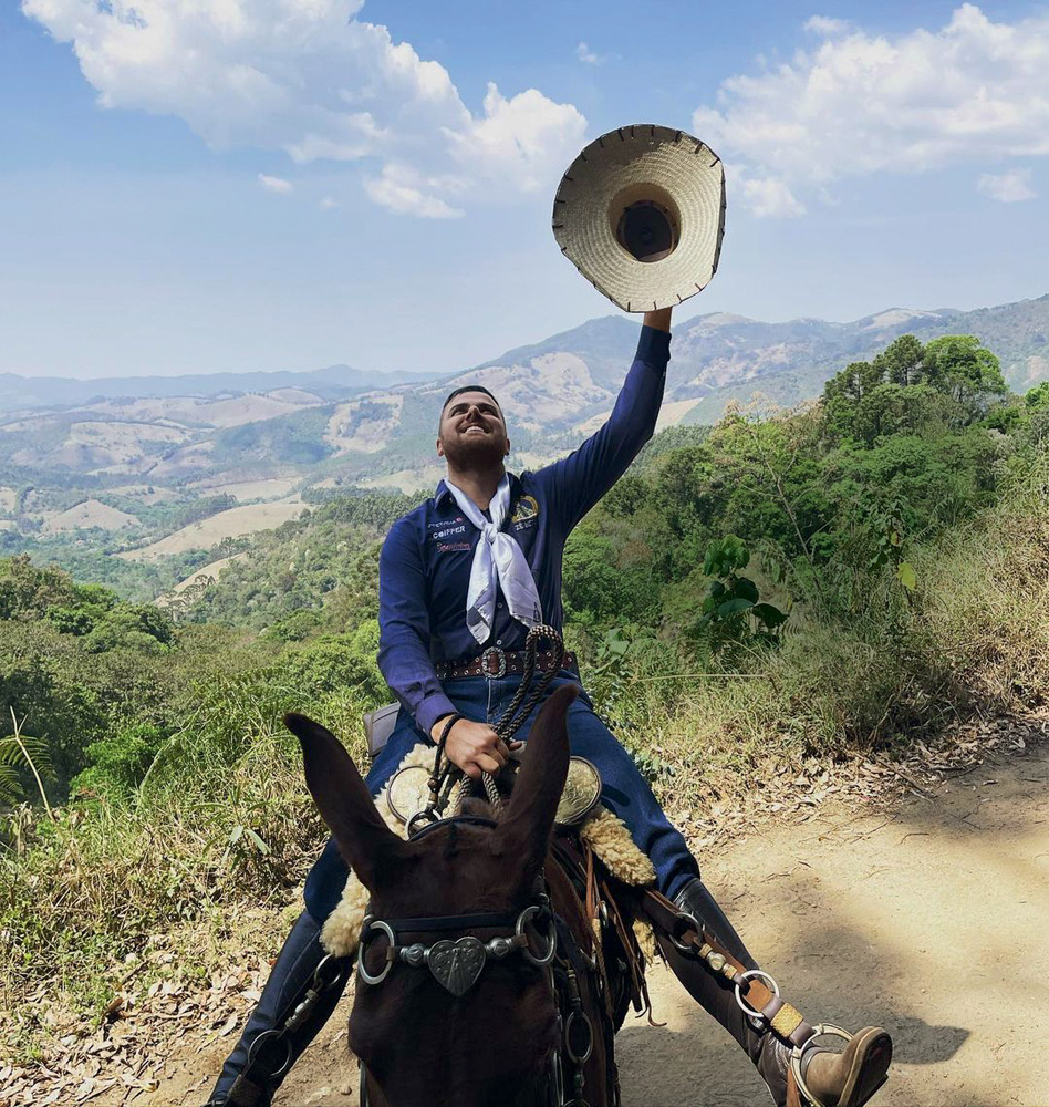 2021ZeNetoCavalgadaInstagramZenetotoscanooficial.jpg Zé Neto em cima de um jumento segurando um chapéu e olhando para cima