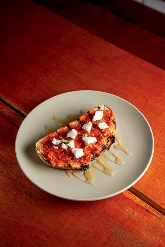 Tostada de sobrasada: embutido desfeito sobre fatia de pão levemente tostada, queijo feta e mel