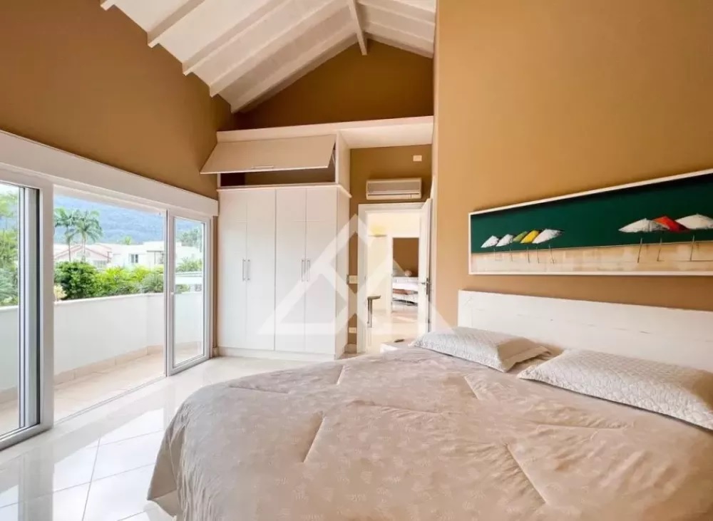 Casa é vendida a R$ 18 milhões e tem vista para o mar (Divulgação) Foto exibe cama de casal, pé-direito alto e janelão com acesso à praia.
