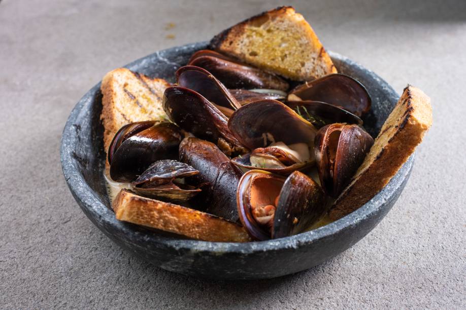 Mexilhões: doçura do leite de coco quebrada pelo limão, servido com bastante cebola e pão de fermentação natural Mexilhões: doçura do leite de coco quebrada pelo limão, servido com bastante cebola e pão de fermentação natural
