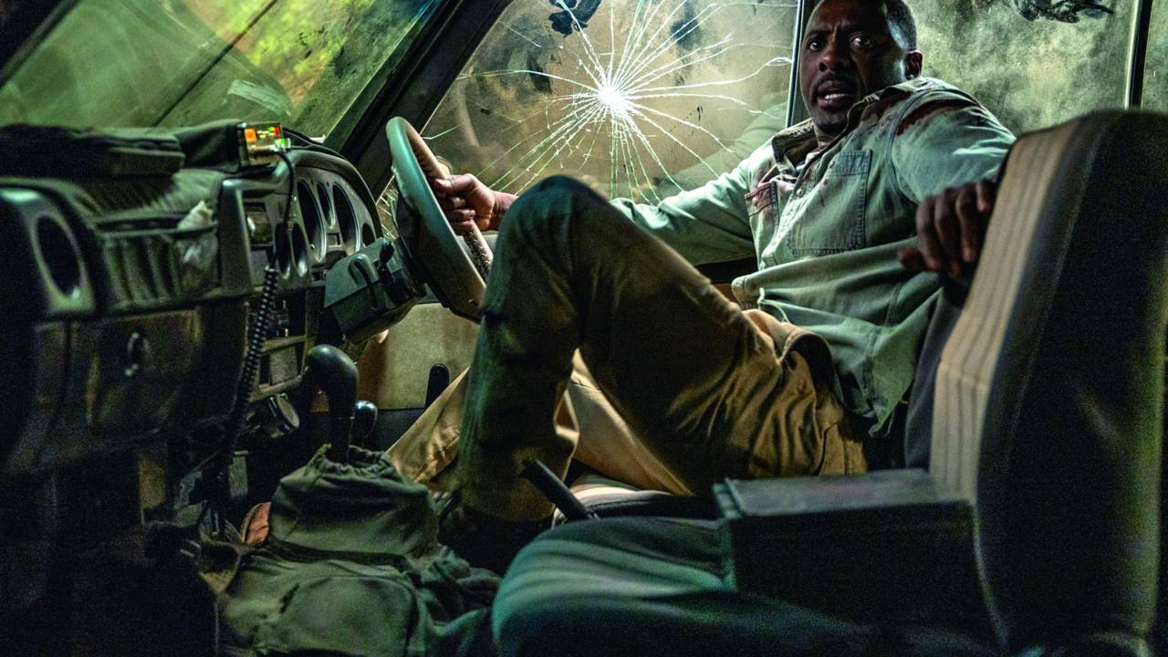 Imagem mostra homem dentro de carro com vidros quebrados. Ele está com roupas sujas e está assustado