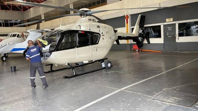 C83ACEF2-4758-439E-9EFD-931B19814C79 Foto mostra hangar com helicóptero.
