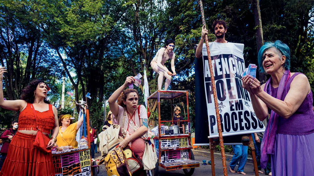 Personagens anônimos caminham pela Praça das Artes, em ‘anonimATO’