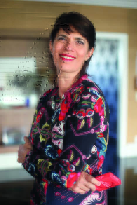 Foto de Elisa Stecca, usando camiseta colorida e sorrindo