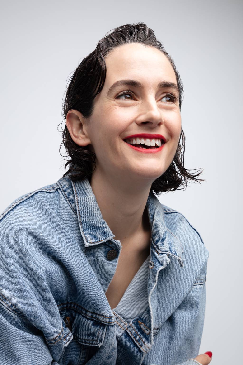 Karla Welch (Mattew Welch) A CEO e ativista Karla Welch sorri olhando para cima. Veste camisa jeans e tem cabelos curtos escorridos.