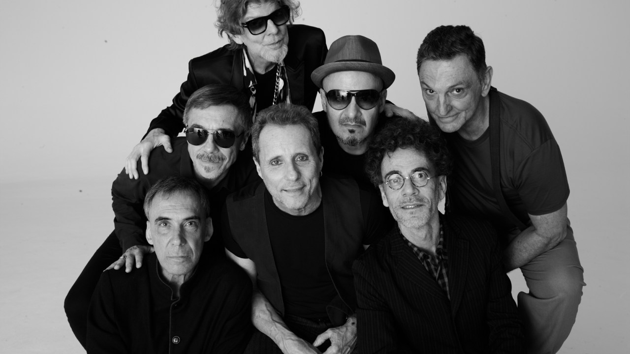 Imagem mostra foto em preto e branco da formação clássica da banda TItãs, com sete homens de roupas pretas