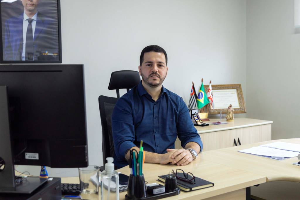 O secretário adjunto Fagotti, à frente do Smart Sampa O secretário adjunto Fagotti, à frente do Smart Sampa.Trata-se de um homem branco e magro, de cabelos e barba escuros. Está sentado em uma mesa de escritório e cruza as mãos em cima dela