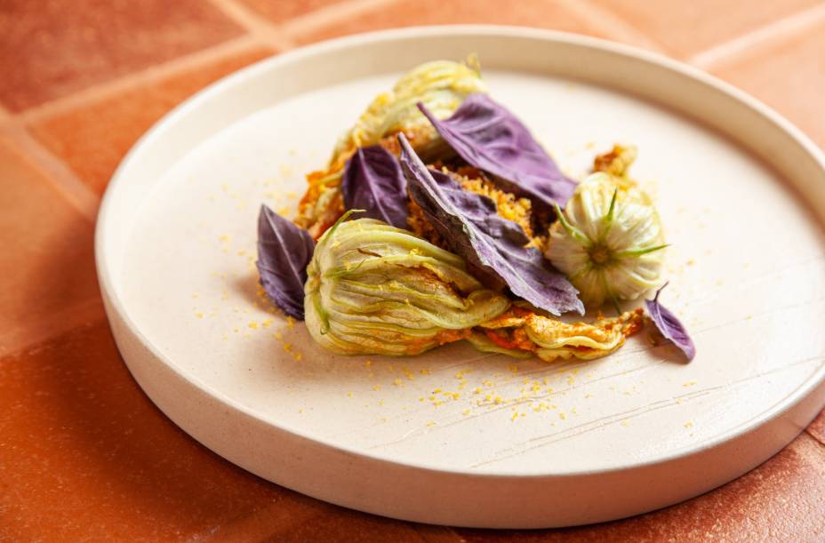 Flor de abobrinha: recheada com siri ao lado de farofa cítrica de maracujá e gema curada ralada Flor de abobrinha: recheada com siri ao lado de farofa cítrica de maracujá e gema curada ralada