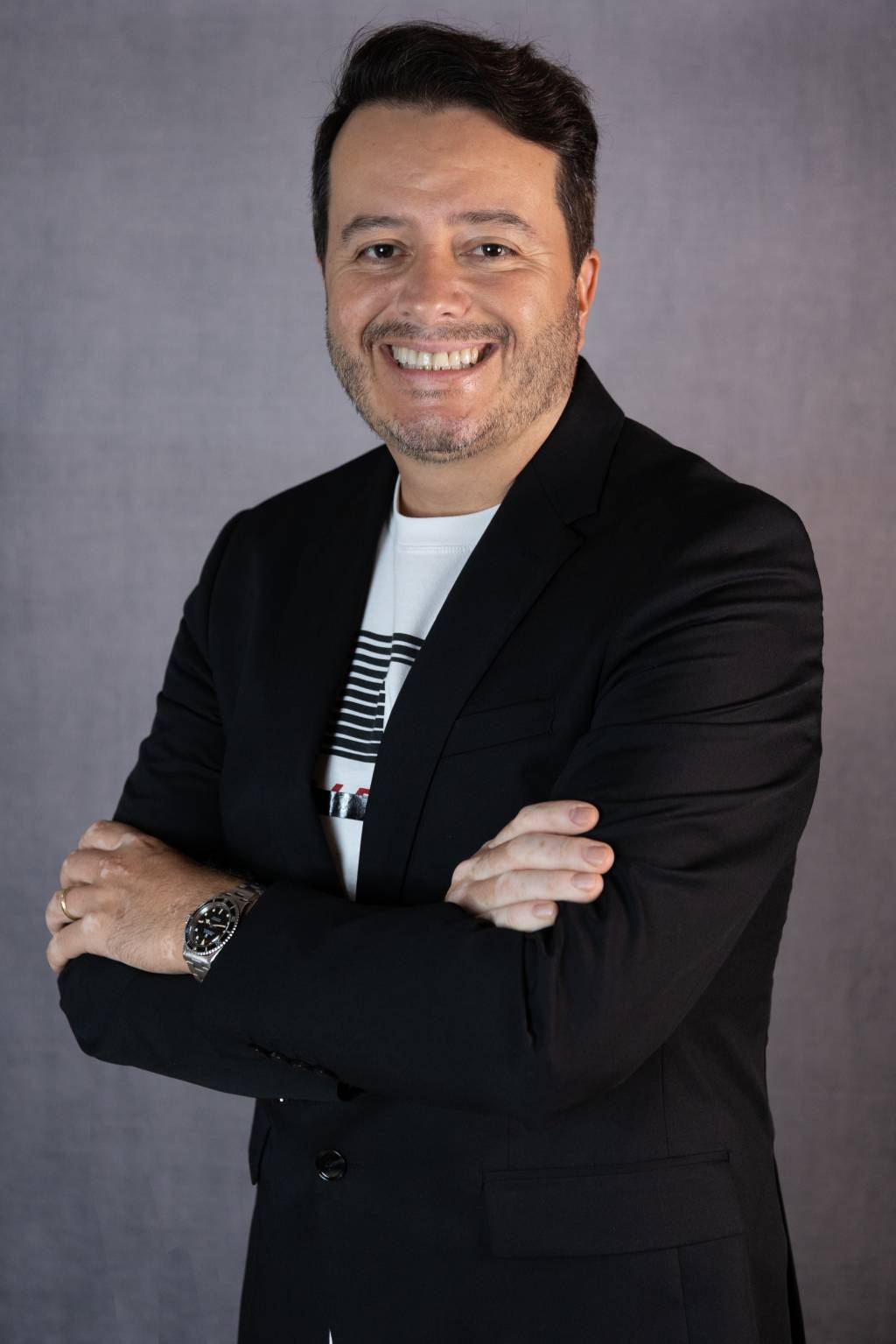 Marcelo Flores – The Great Gatsby Party (Studio Gobbi-Bruna Gobbi) Marcelo Flores sorri para a foto. Tem cabelos pretos curtos, pele branca e veste blazer preto com camiseta branca.