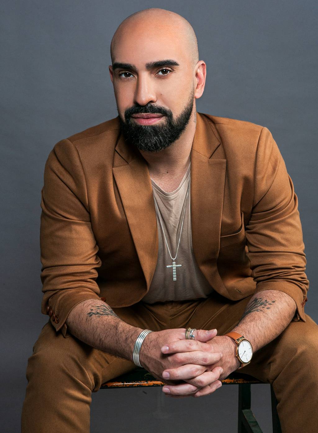 Thiago Gimenes (Carlo Locatelli-Divulgação) Homem branco e careca com barba preta encara a câmera. Veste blazer marrom.