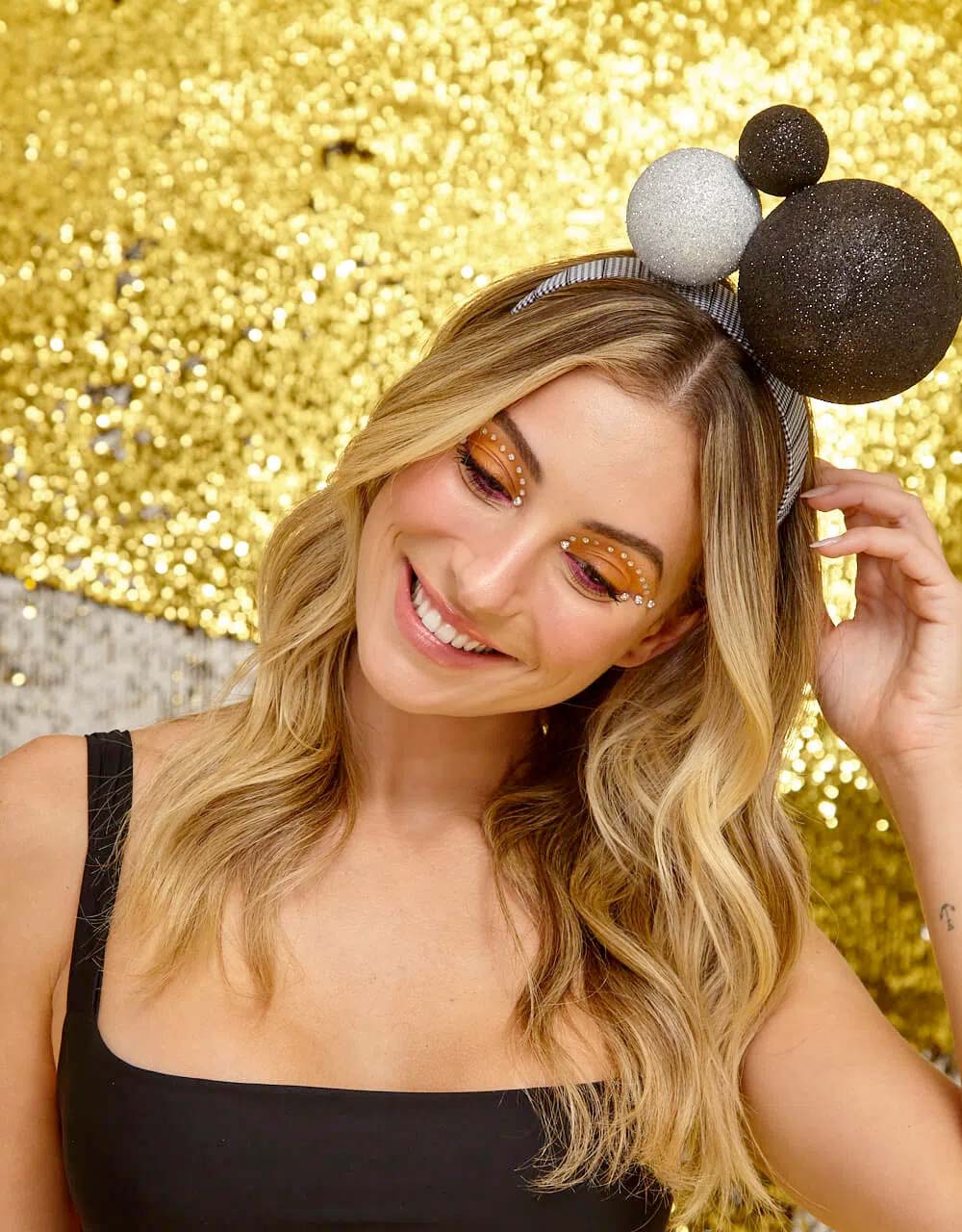 Modelo magra, branca e loira usa tiara com bolas nas cores preta e branca. Possui glitter