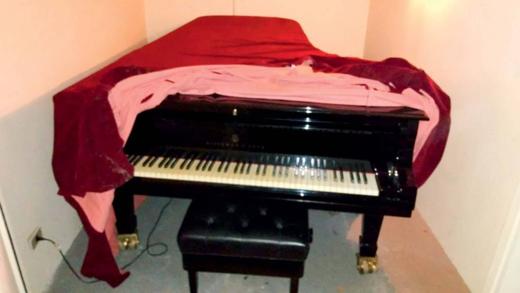 steinway sons hotel maksoud plaza leiloado Piano Steinway & Sons antigo, coberto por um tecido de veludo vermelho. Está em um cômodo do hotel Maksoud Plaza que tem piso de carpete cinza