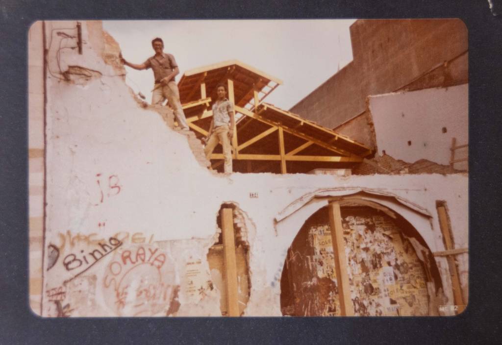 Café Piu Piu Imagem mostra construção de prédio com dois homens em cima de parede