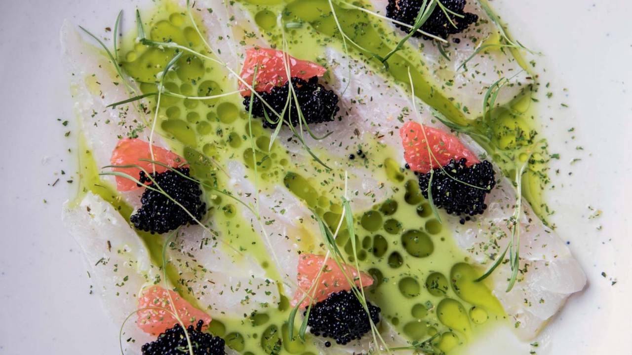Èze fatias cruas de peixe do dia com emulsão de pimenta jalapeño, ovas de peixe-voador, laranja sanguínea e óleo de salsão