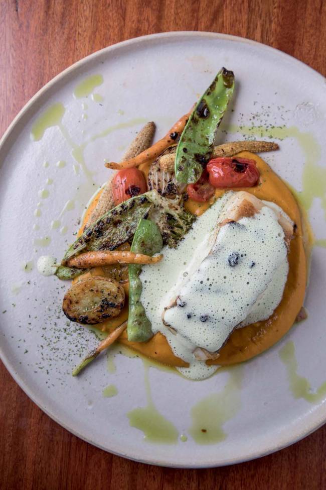 Peixe na brasa Èze peixe na brasa, que pode ser uma pescada-amarela, com purê de abóbora, legumes salteados e emulsão de erva-doce