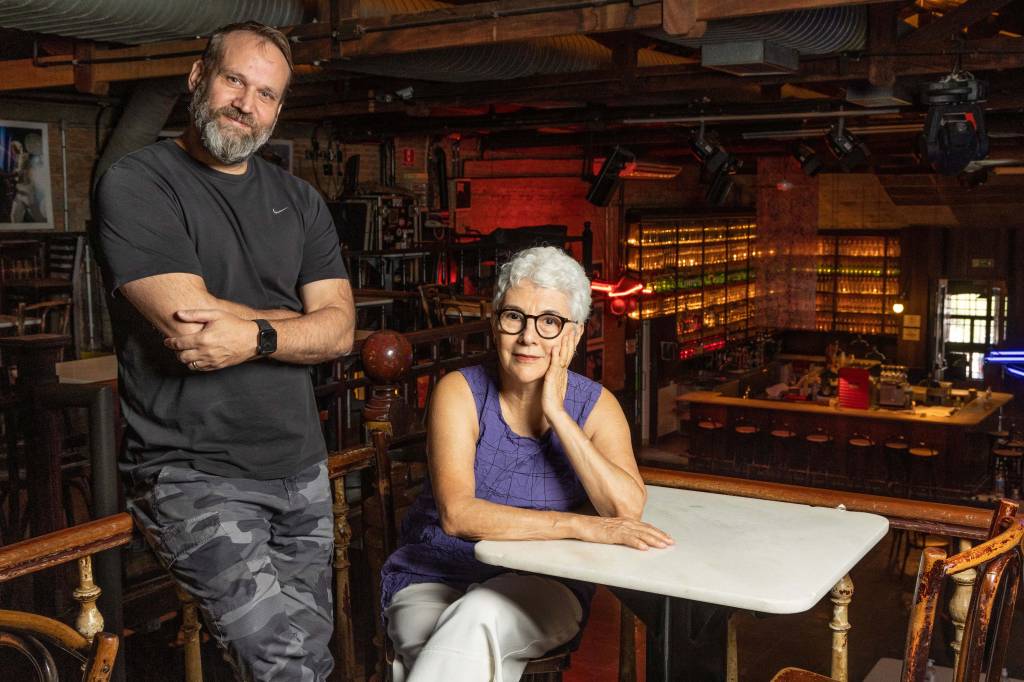 São Paulo, SP 20/03/2023 – Aniversário Café Piu Piu. Foto: Leo Martins Imagem mostra homem em pé e mulher sentada, com bar ao fundo