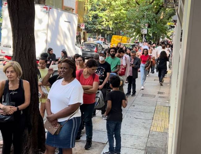 Fila de pessoas em calçada