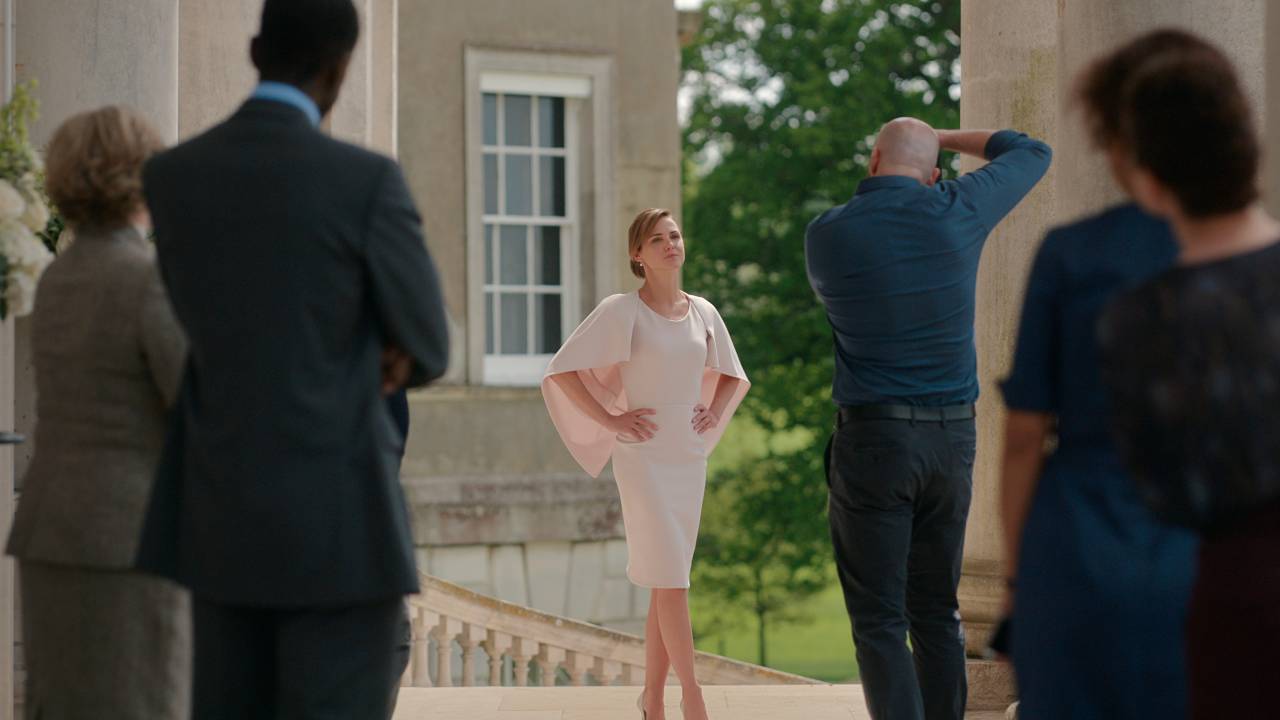 Mulher de vestido branco posa para fotos em residência