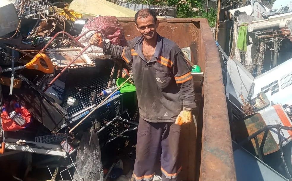Um homem de uniforme manuseando ferro velho
