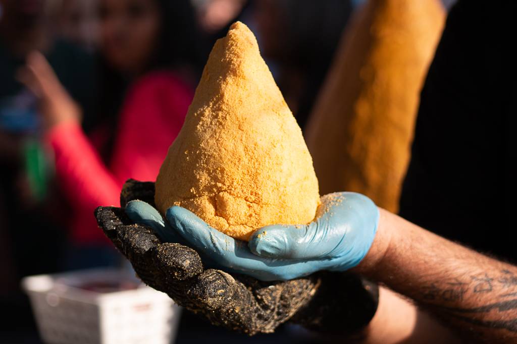 13 – Big Food Festival (Jean Santiago-Divulgação) (1) Mãos com luvas seguram uma coxinha gigante.