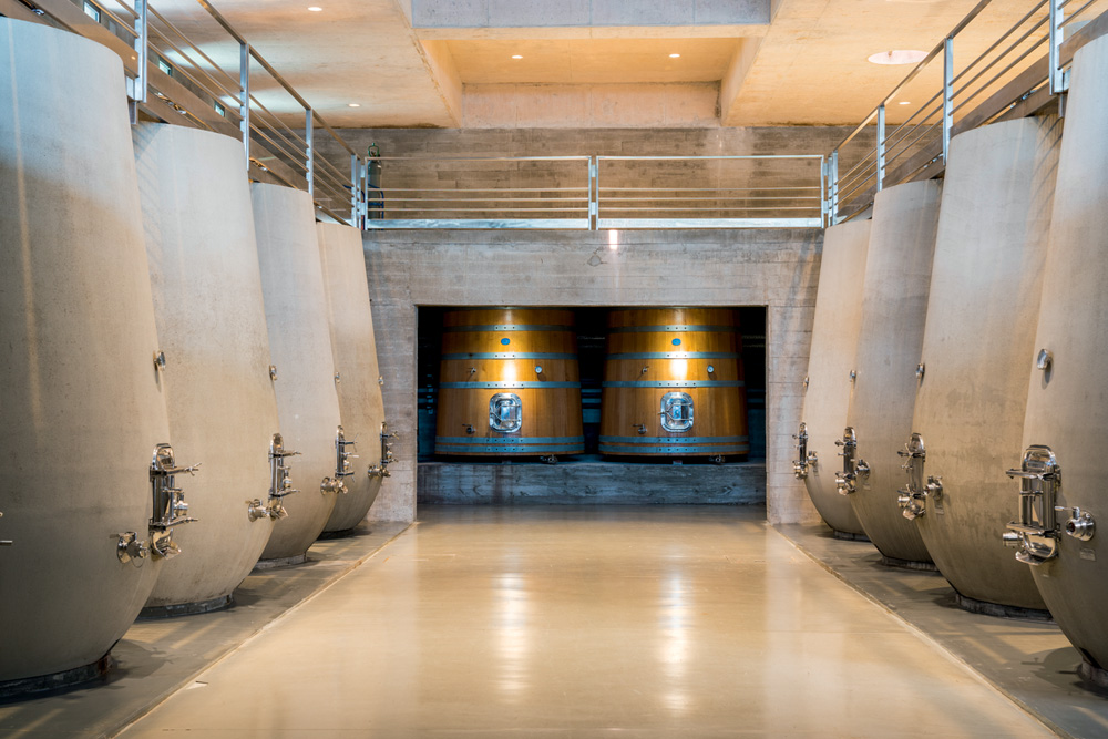 Bodega Garzon Salão com tulipas enormes de concreto nas laterais e barris gigantes de madeira ao fundo
