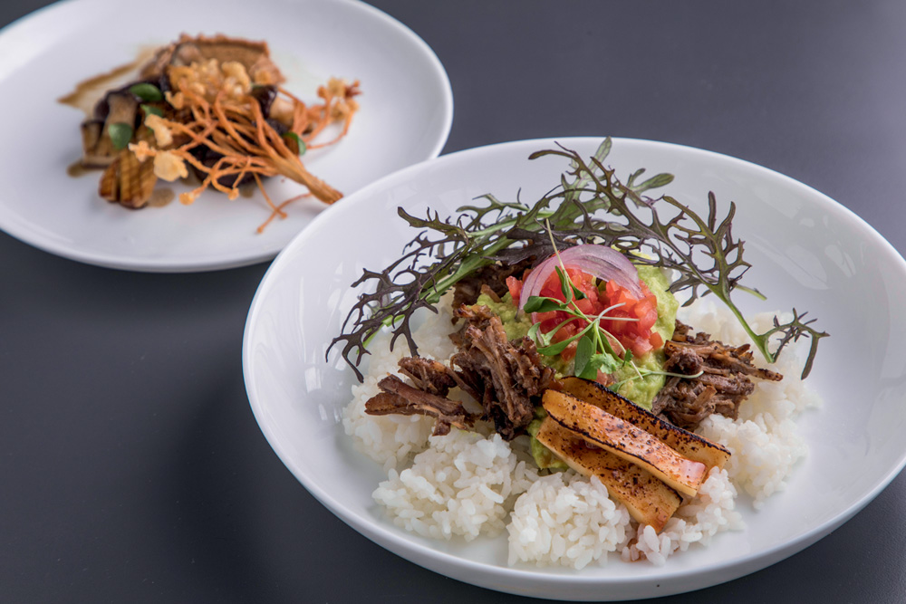 Prato fundo de louça branca com arroz coberto por carne, abacate, tomate e cebola-roxa.