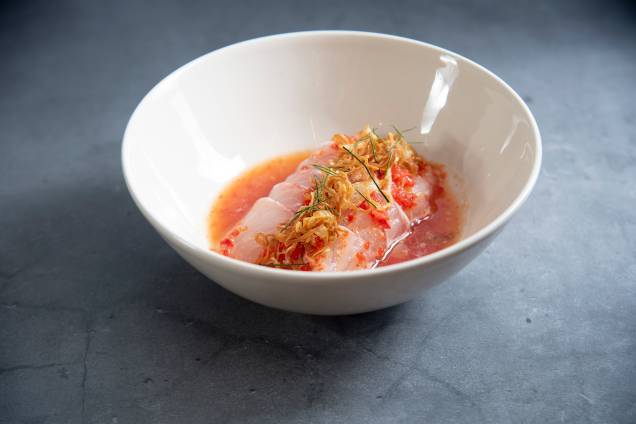 Pla dip: fatias de peixe cru ao nahm jim salpicadas de chips de chalota e folhas de limão kaffir Pla dip: fatias de peixe cru ao nahm jim salpicadas de chips de chalota e folhas de limão kaffir