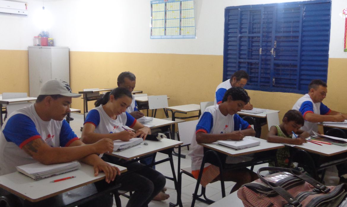 adultos em sala de aula estudando
