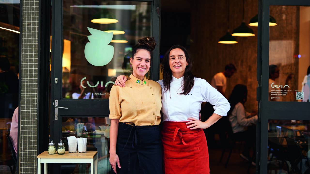 Duas chefs abraçadas em frente a fachada do restaurante Cuia.