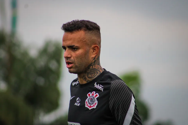 um homem com o pescoço tatuado vestindo a camisa do corinthians