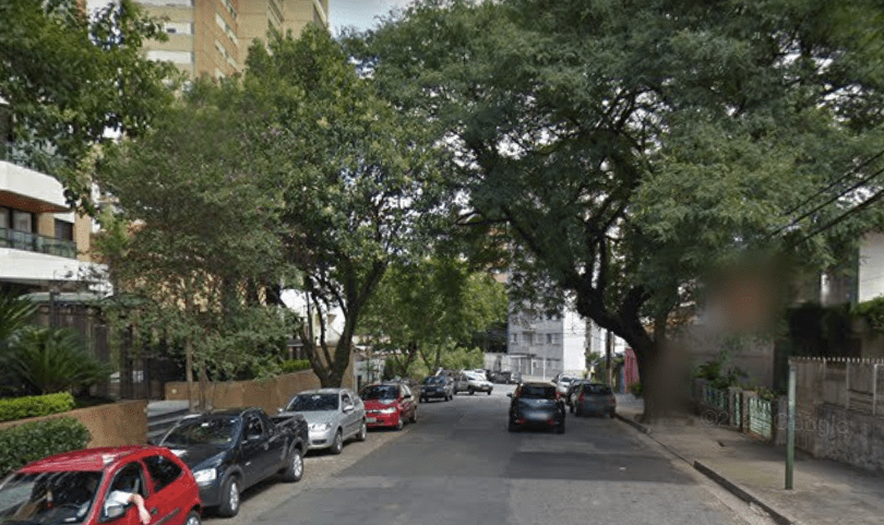 rua arborizada com carros estacionados