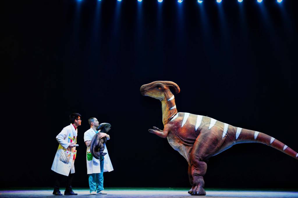 Circo Internacional da China Espetáculo com duas pessoas olhando para maquete de dinossauro.