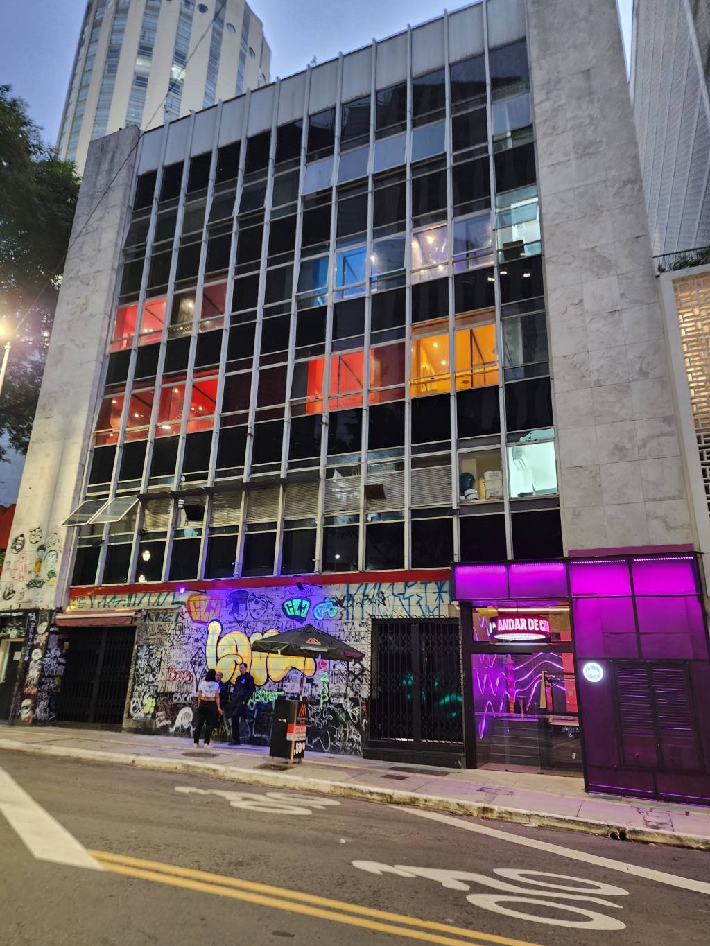 Suítes Andar de Cima-Crédito-Divulgação (14) Fachada de prédio cinza com janelas pretas e coloridas nos tons vermelho, amarelo e azul