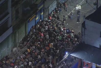 Imagem aérea mostra rua cheia de pessoas durante a noite