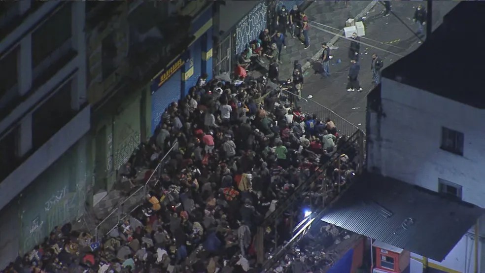 Imagem aérea mostra rua cheia de pessoas durante a noite