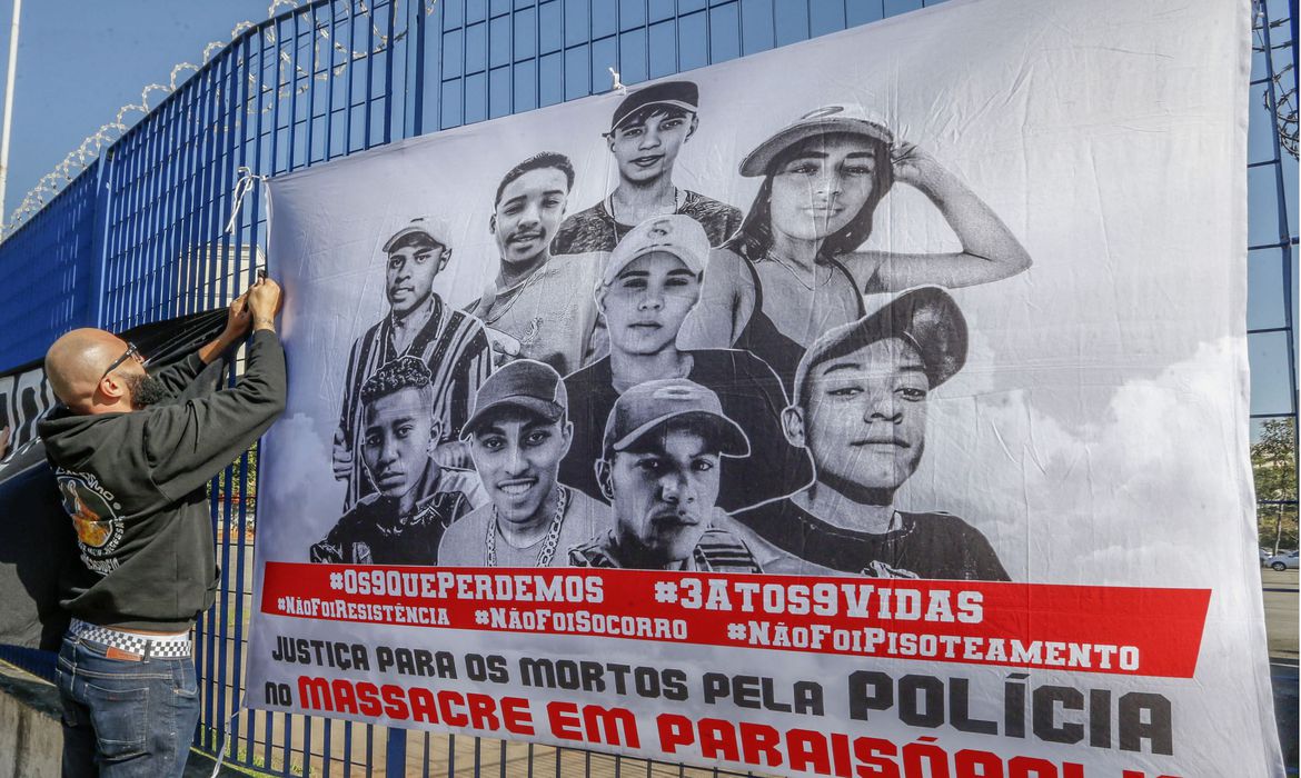 uma faixa com o rosto das vítimas