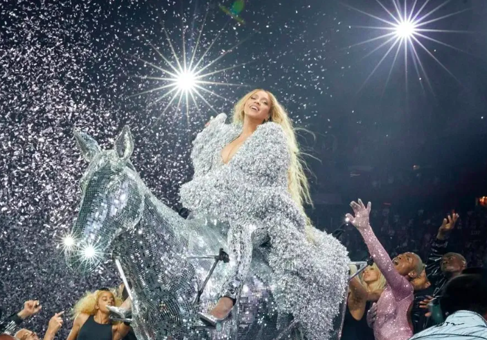 beyoncé vestida com uma roupa prateada em cima de um cavalo prateado