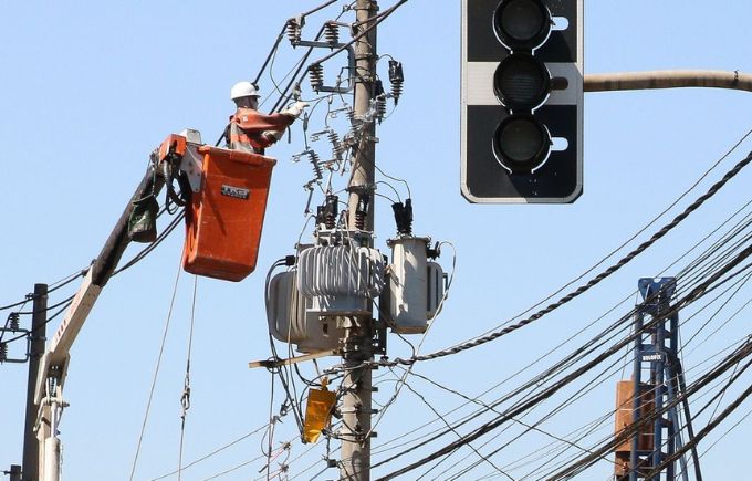 Funcionário repara rede de energia elétrica